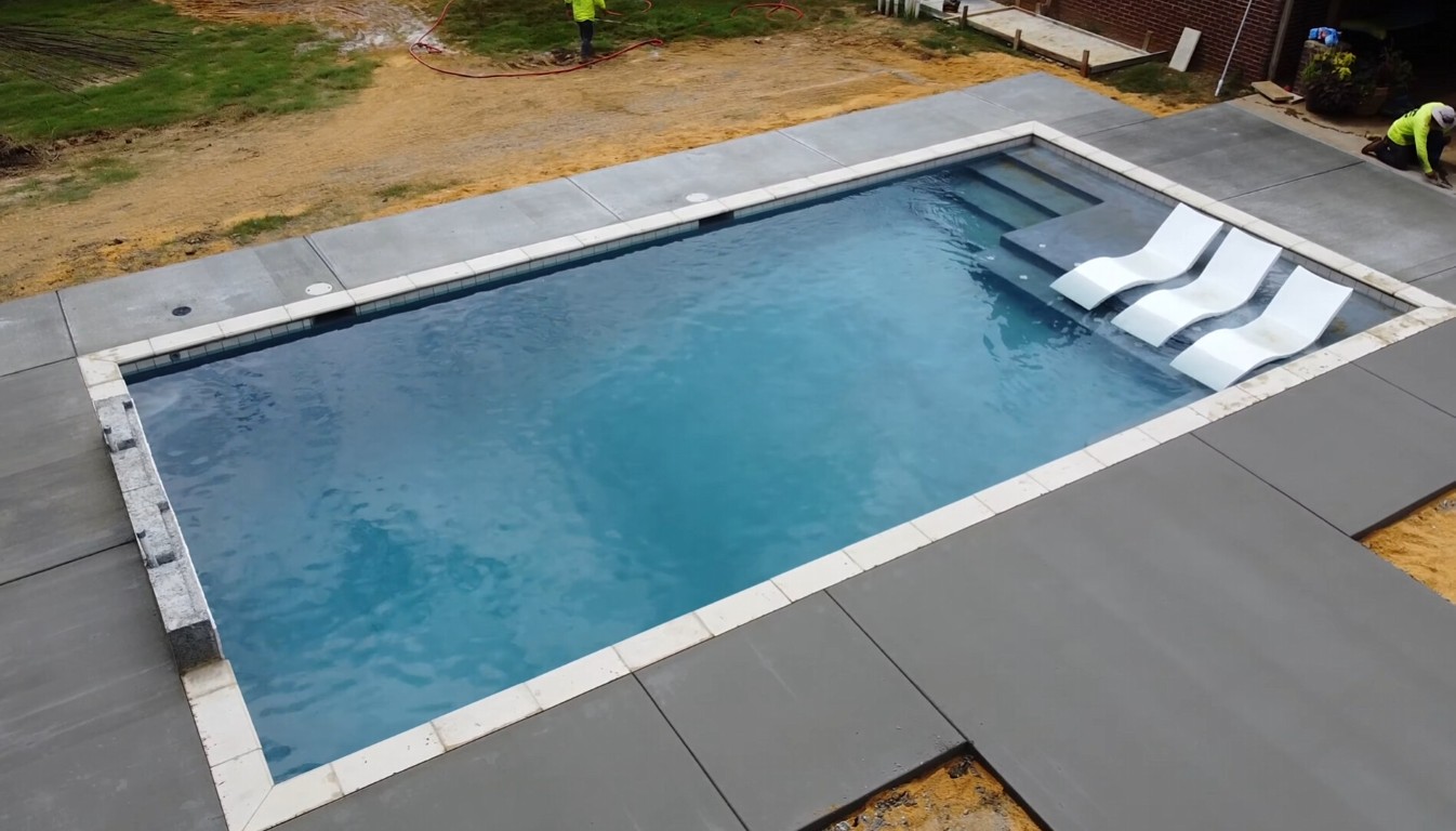 Newly installed concrete pool deck surrounding a residential swimming pool