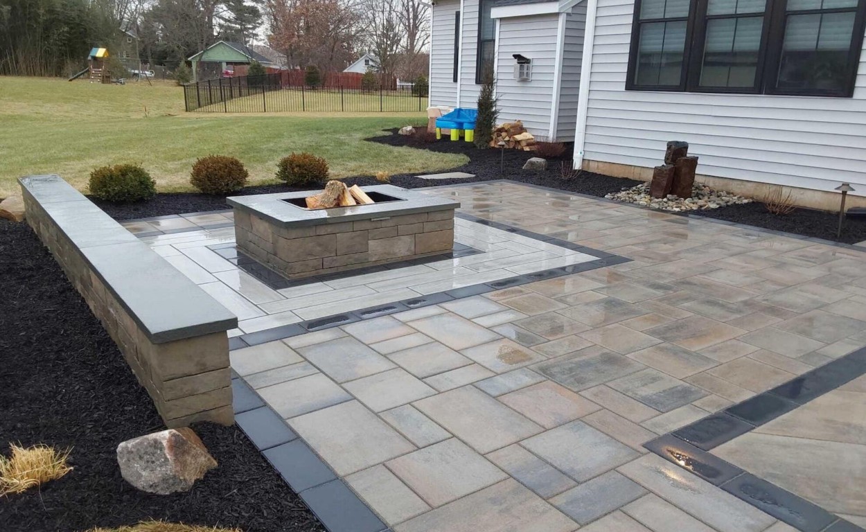 Custom stamped concrete patio with fire pit in a residential backyard